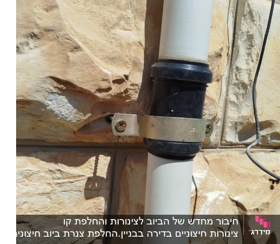 צינור מחובר לקיר אבן עם תושבת מתכת